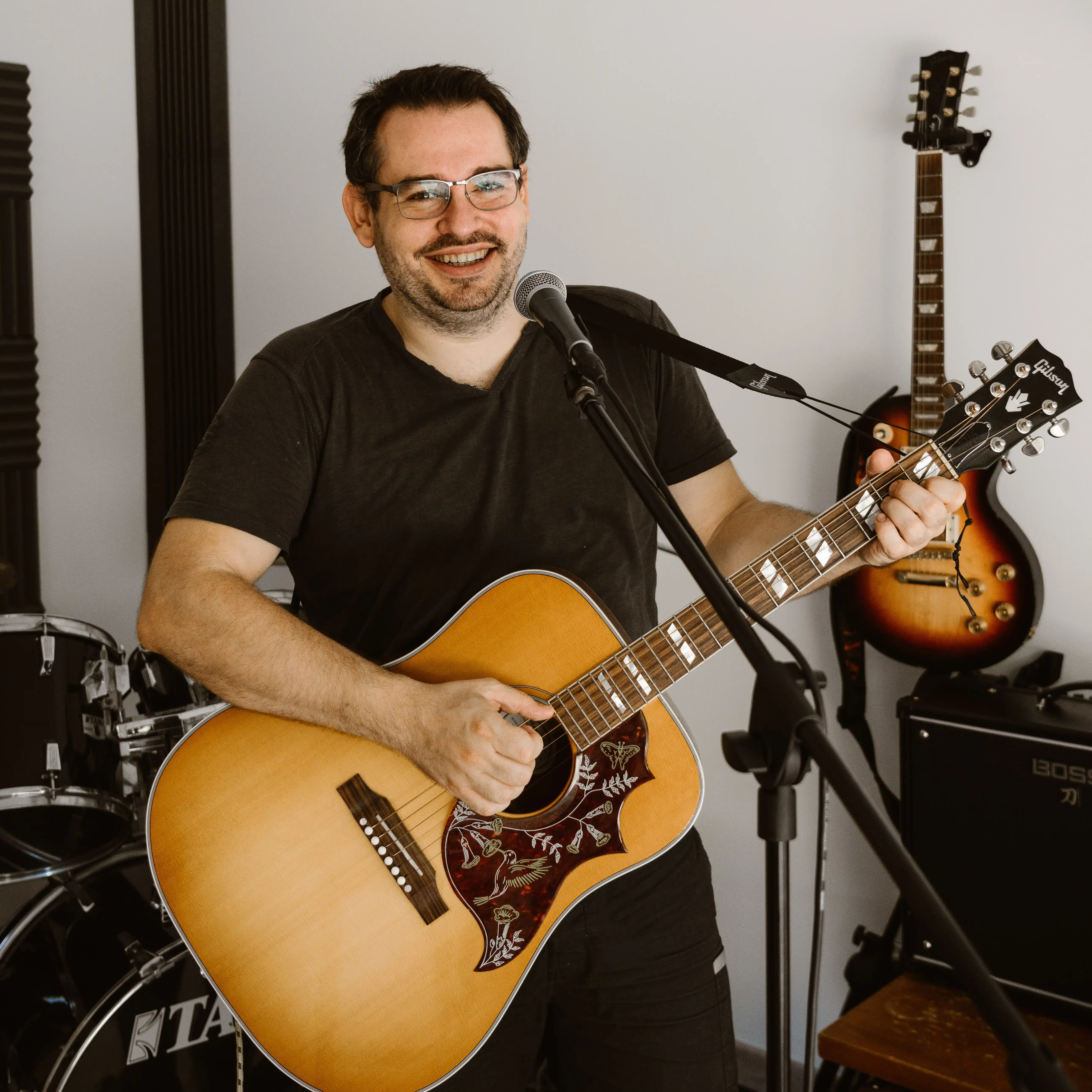 Julien Maudoux, professeur de musique, tenant une guitare